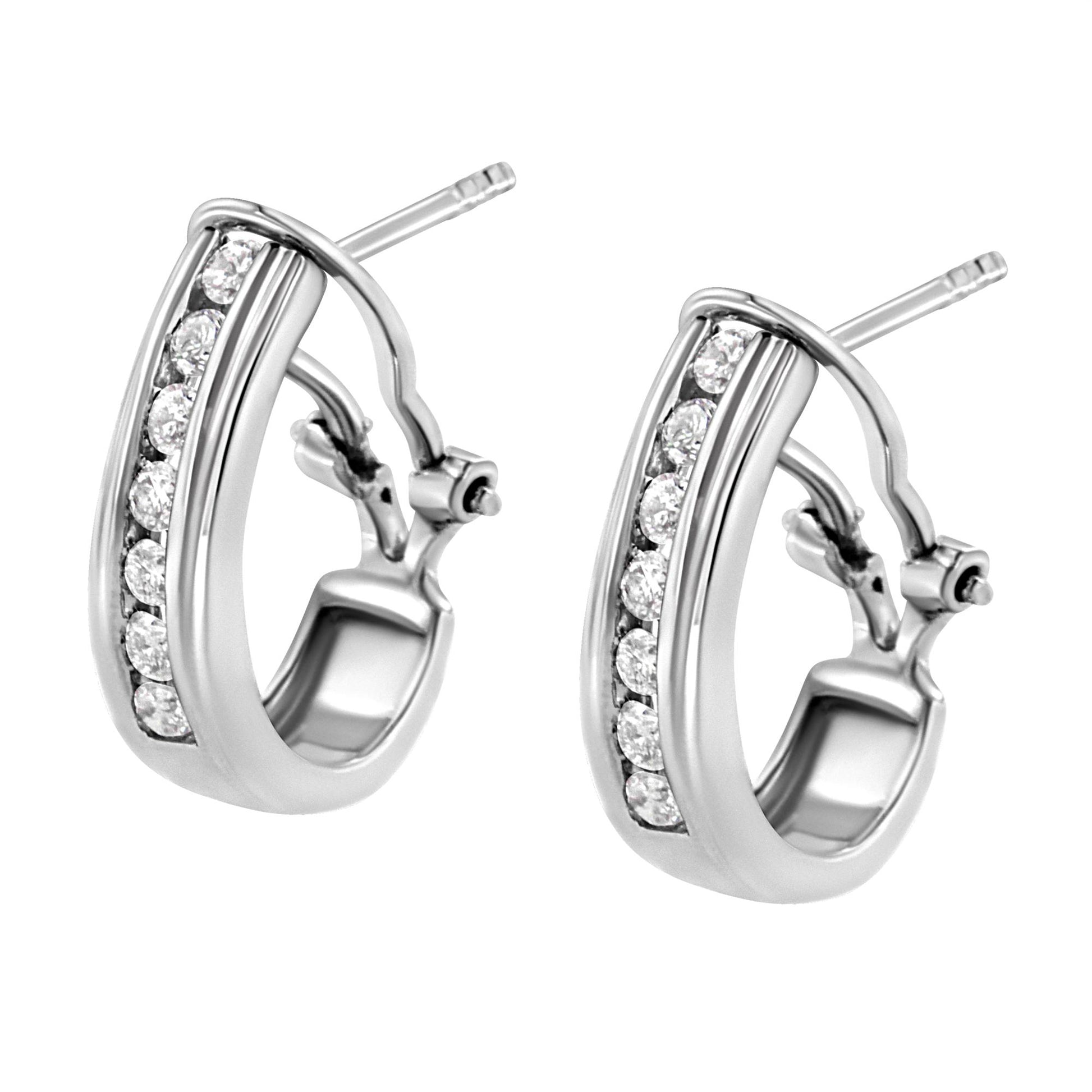 Pair of white metal hoop earrings with round white gemstones in channel setting, shown at an angled close-up view.