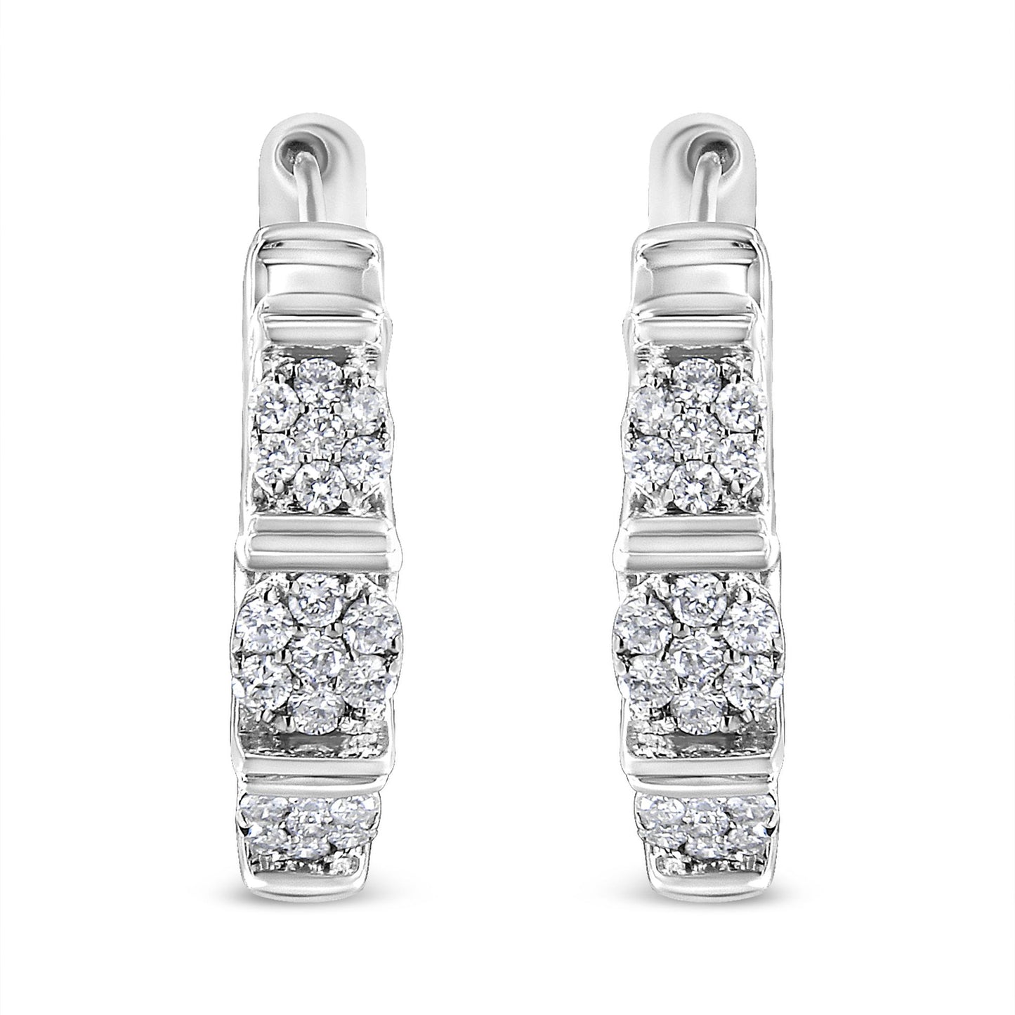 Front-facing shot of white metal hoop earrings with clusters of round white gemstones in prong settings arranged vertically.