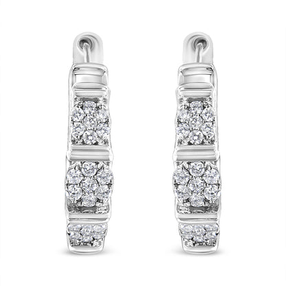 Front-facing shot of white metal hoop earrings with clusters of round white gemstones in prong settings arranged vertically.