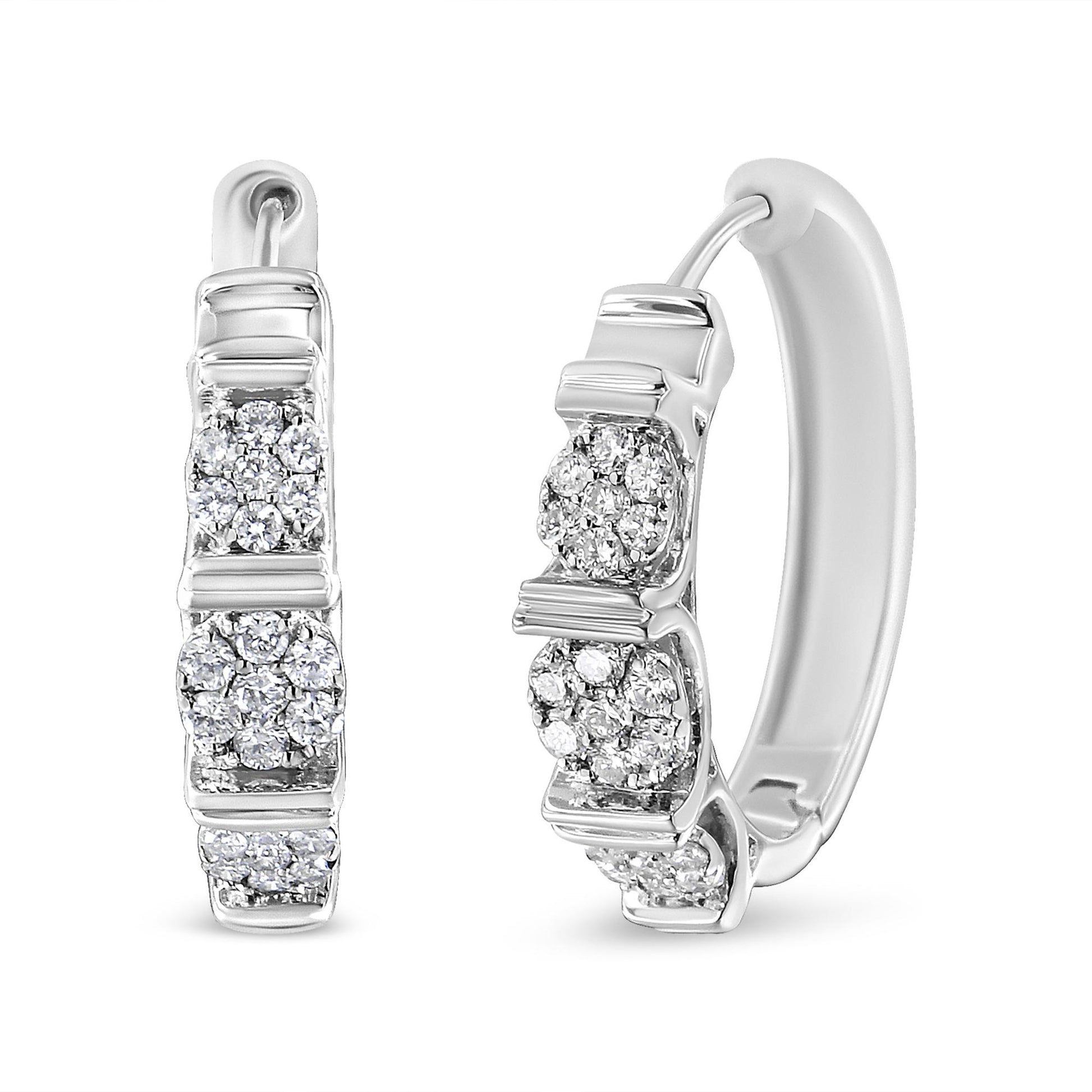 Pair of white metal hoop earrings with clusters of round white gemstones in prong settings, shown from front and angled side views.