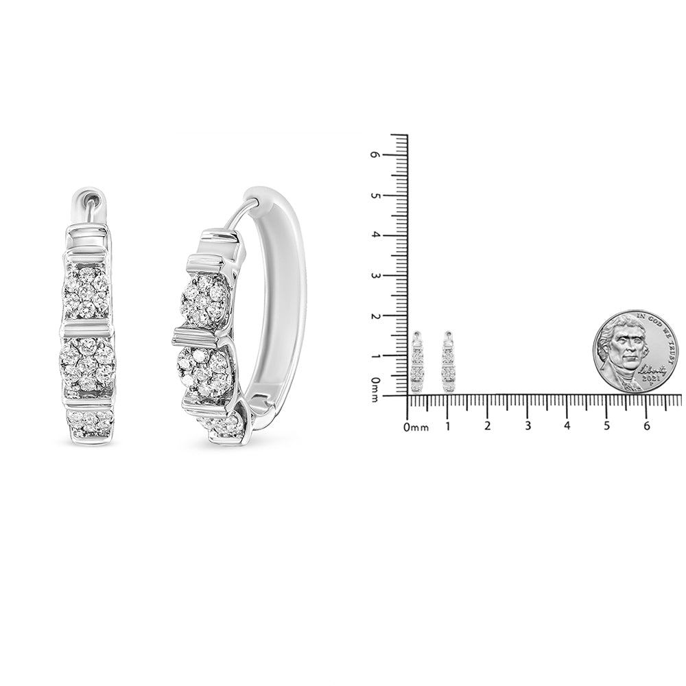 Front and side view of white metal hoop earrings with clusters of white round gemstones in prong settings, shown next to a ruler and coin for size reference.