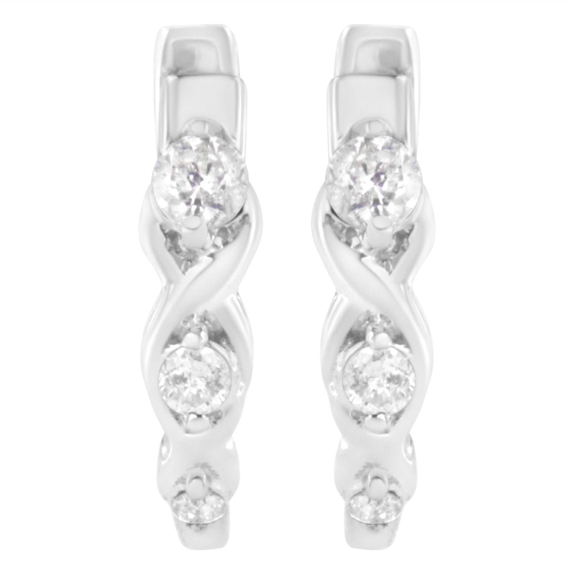 Front angle view of white metal earrings with an intertwined design and three round white gemstones in prong settings on each earring.