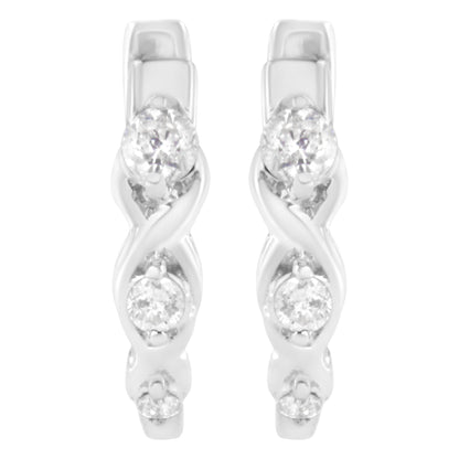 Front angle view of white metal earrings with an intertwined design and three round white gemstones in prong settings on each earring.