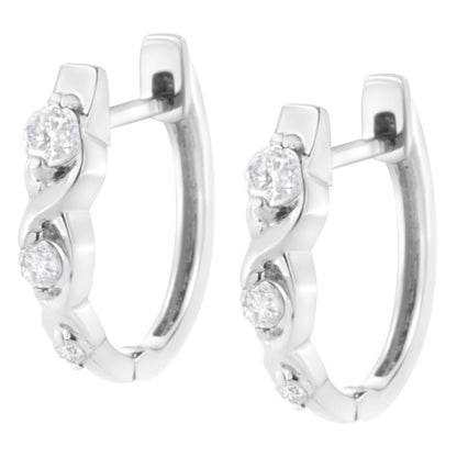 Pair of white metal hoop earrings set with multiple round white gemstones, shown in a front angled close-up view.