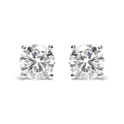 Pair of white metal stud earrings with round white gemstones in 4-prong settings, front view.