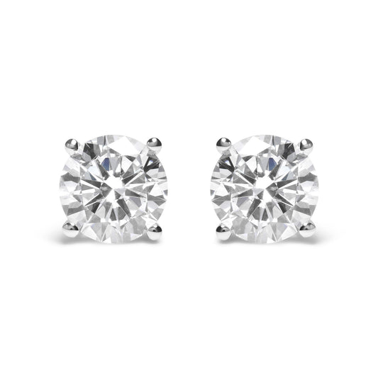 Pair of white metal stud earrings with round white gemstones in 4-prong settings, front view.