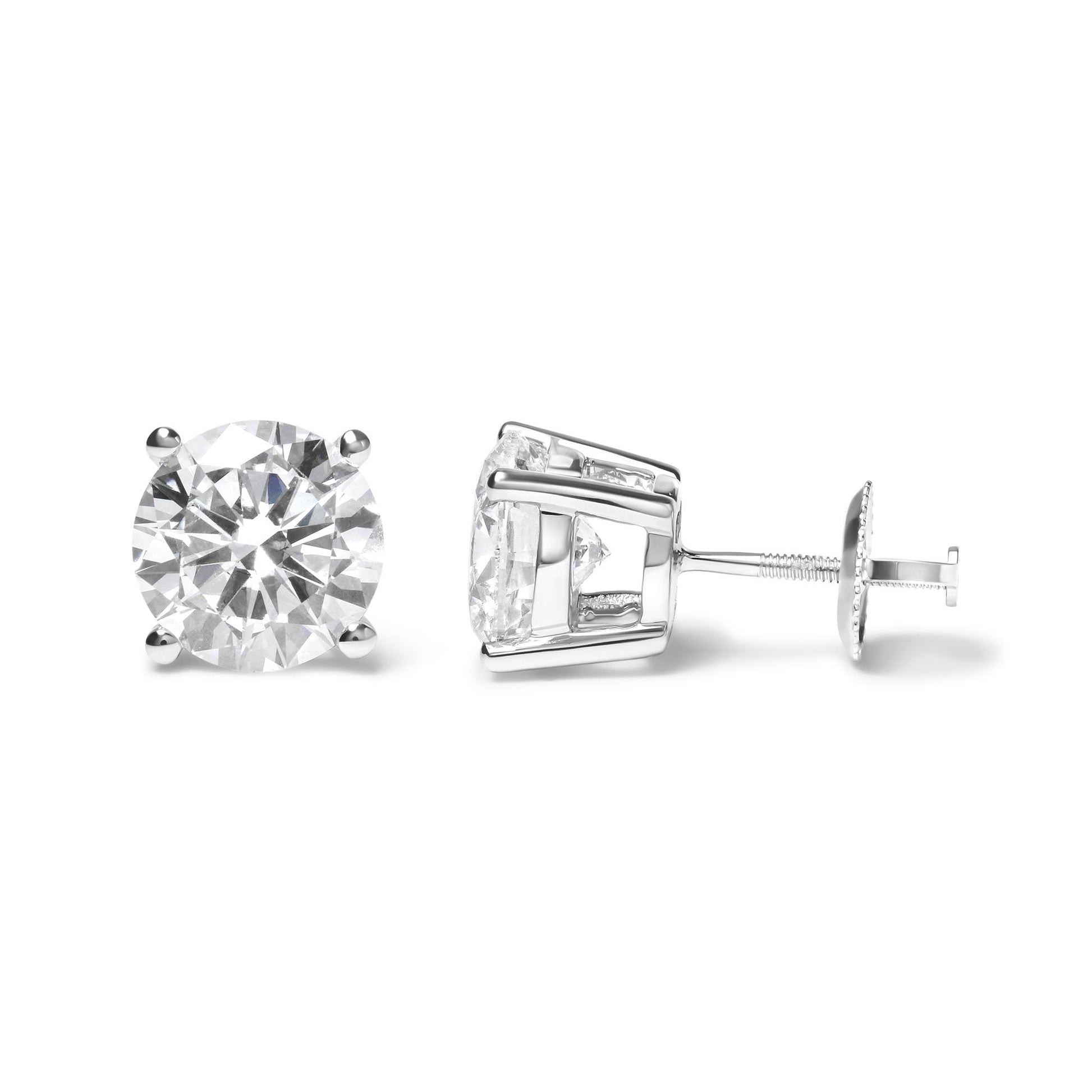 Pair of white metal stud earrings with round white gemstones in four-prong settings, shown from front and side angles.