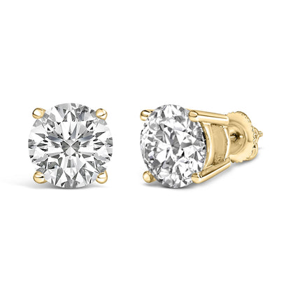 Pair of yellow metal stud earrings with round white gemstones in 4-prong settings, shown in a front and angled side view on a white background.
