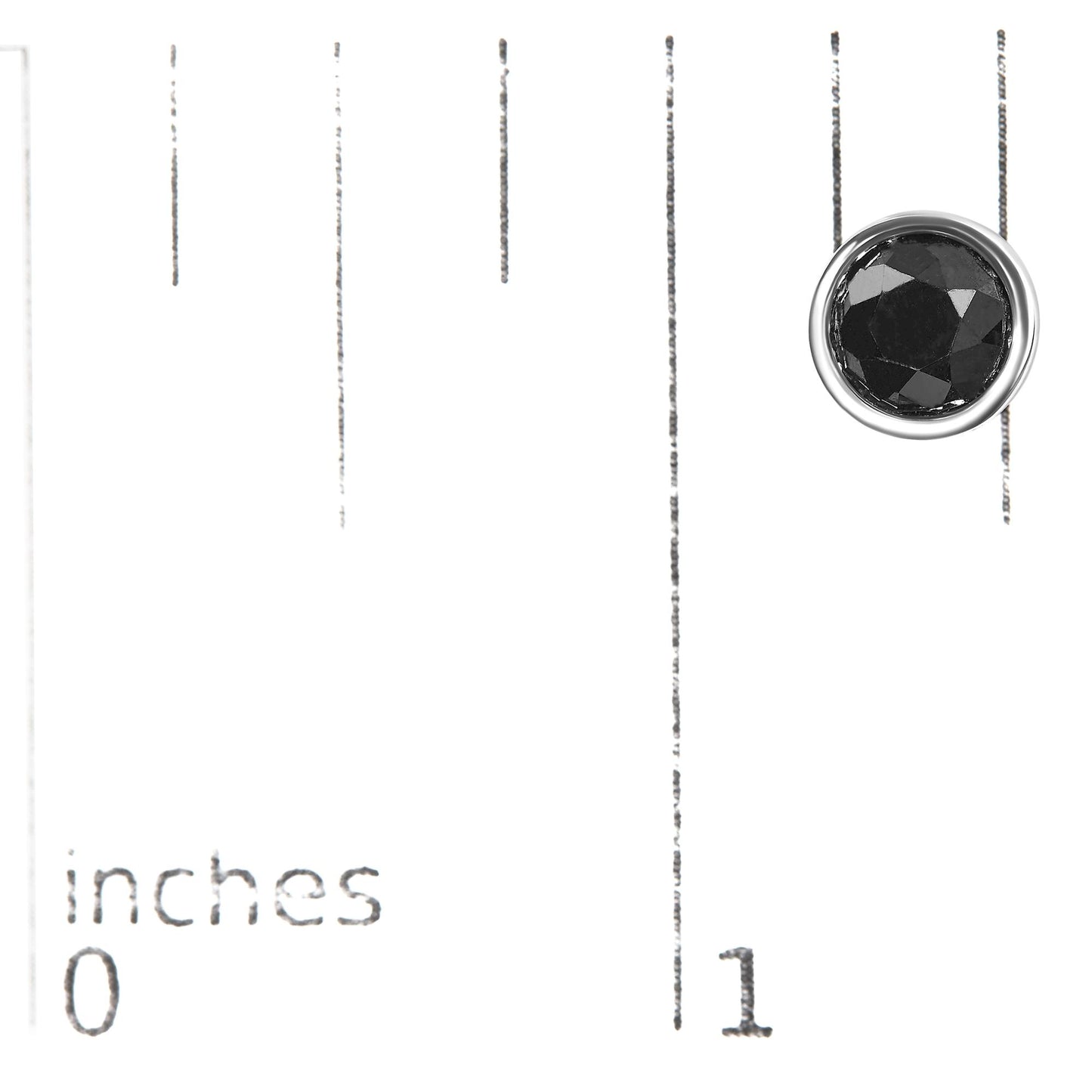 Close-up shot of a single white metal earring with a round black gemstone in a bezel setting on a ruler for size reference.