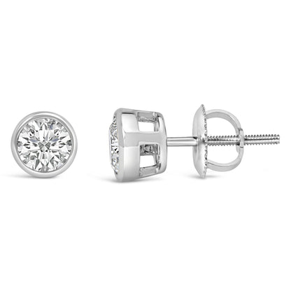 Front and side views of a pair of white metal stud earrings with round white gemstones in bezel settings on a white background.