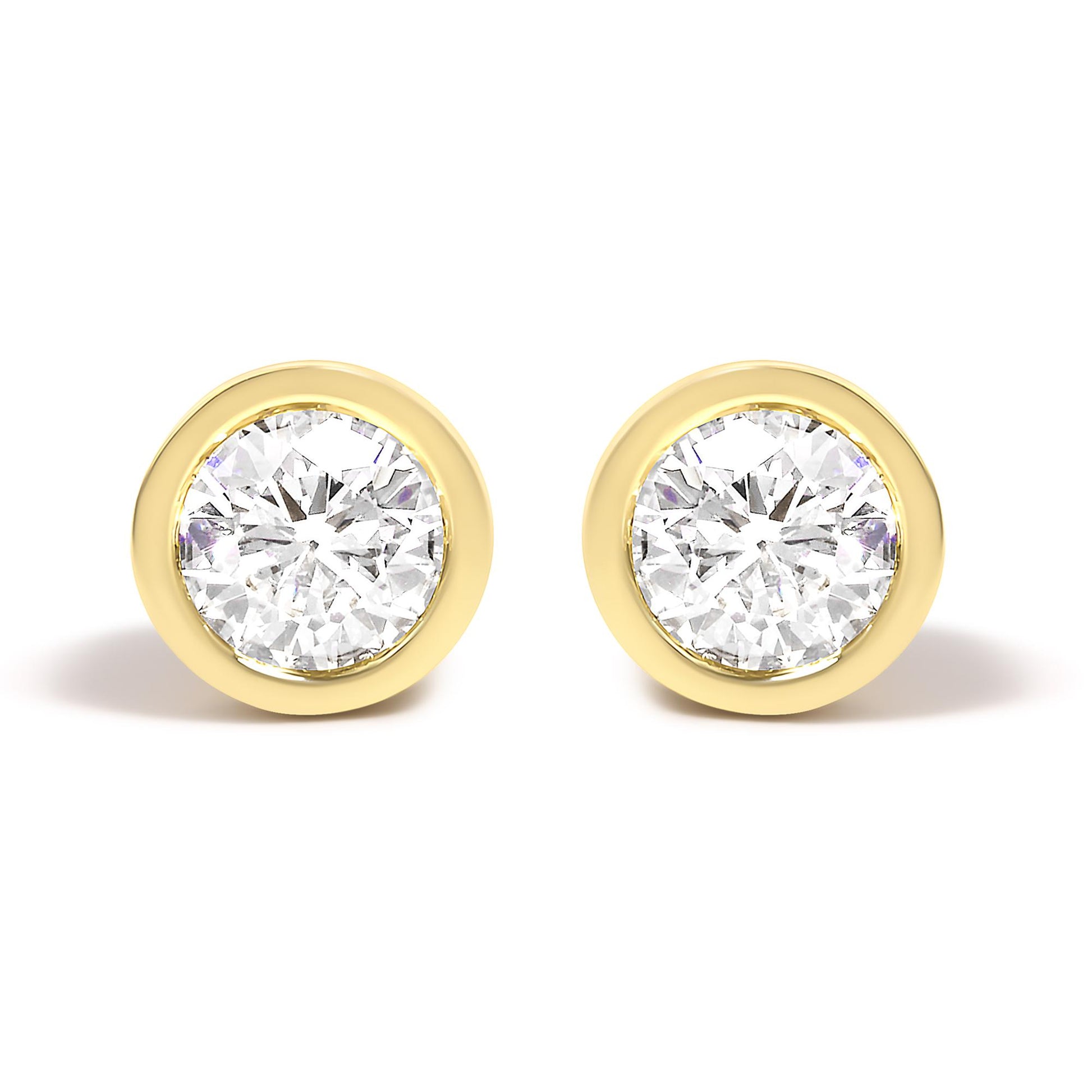 Front view of a pair of yellow metal stud earrings each featuring a round white gemstone in a bezel setting.