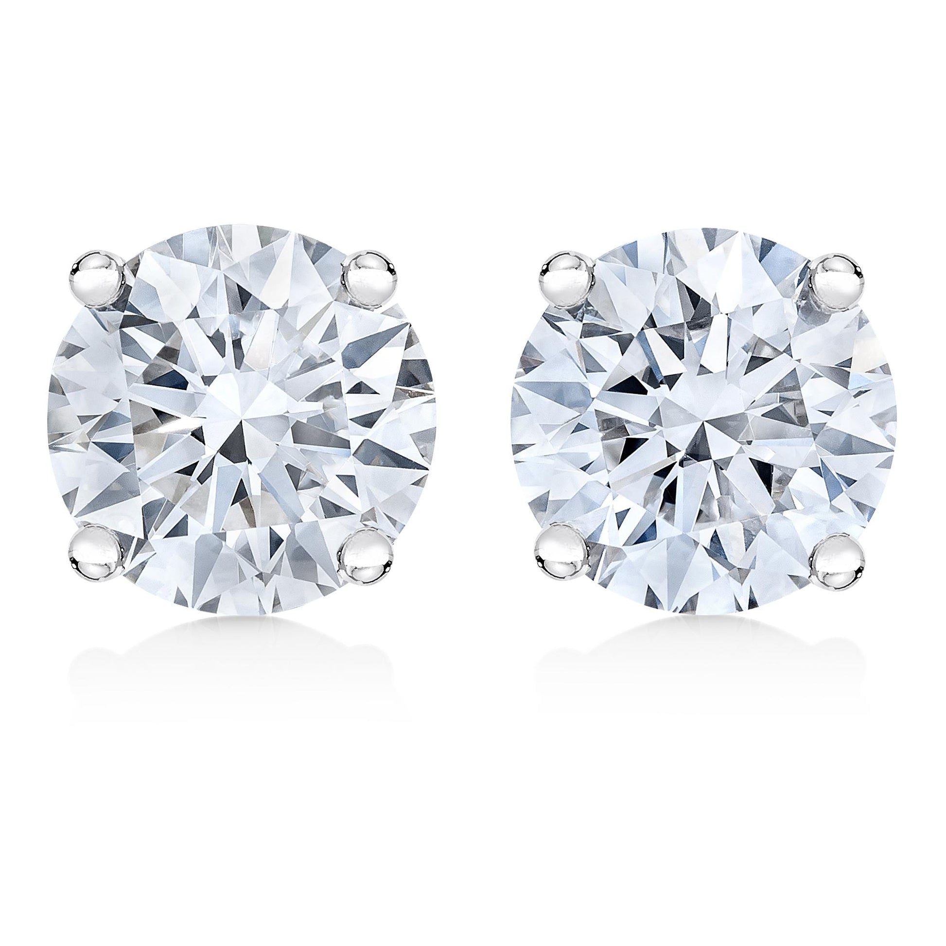 Close-up front view of a pair of white metal stud earrings, each featuring a round white gemstone in a four-prong setting.