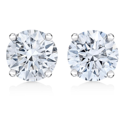 Close-up front view of a pair of white metal stud earrings, each featuring a round white gemstone in a four-prong setting.