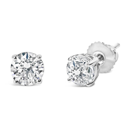 Pair of white metal stud earrings with round white gemstones in four-prong settings, shown from front and side angles.