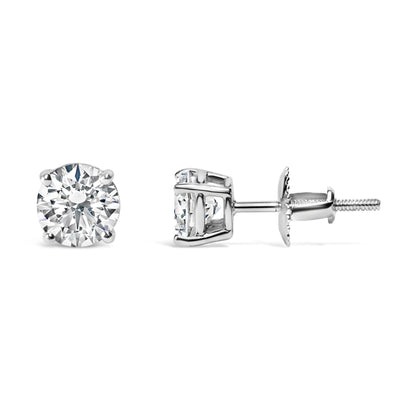 Pair of white metal stud earrings with round white gemstones in four-prong settings, shown from front and side angles on a white background.