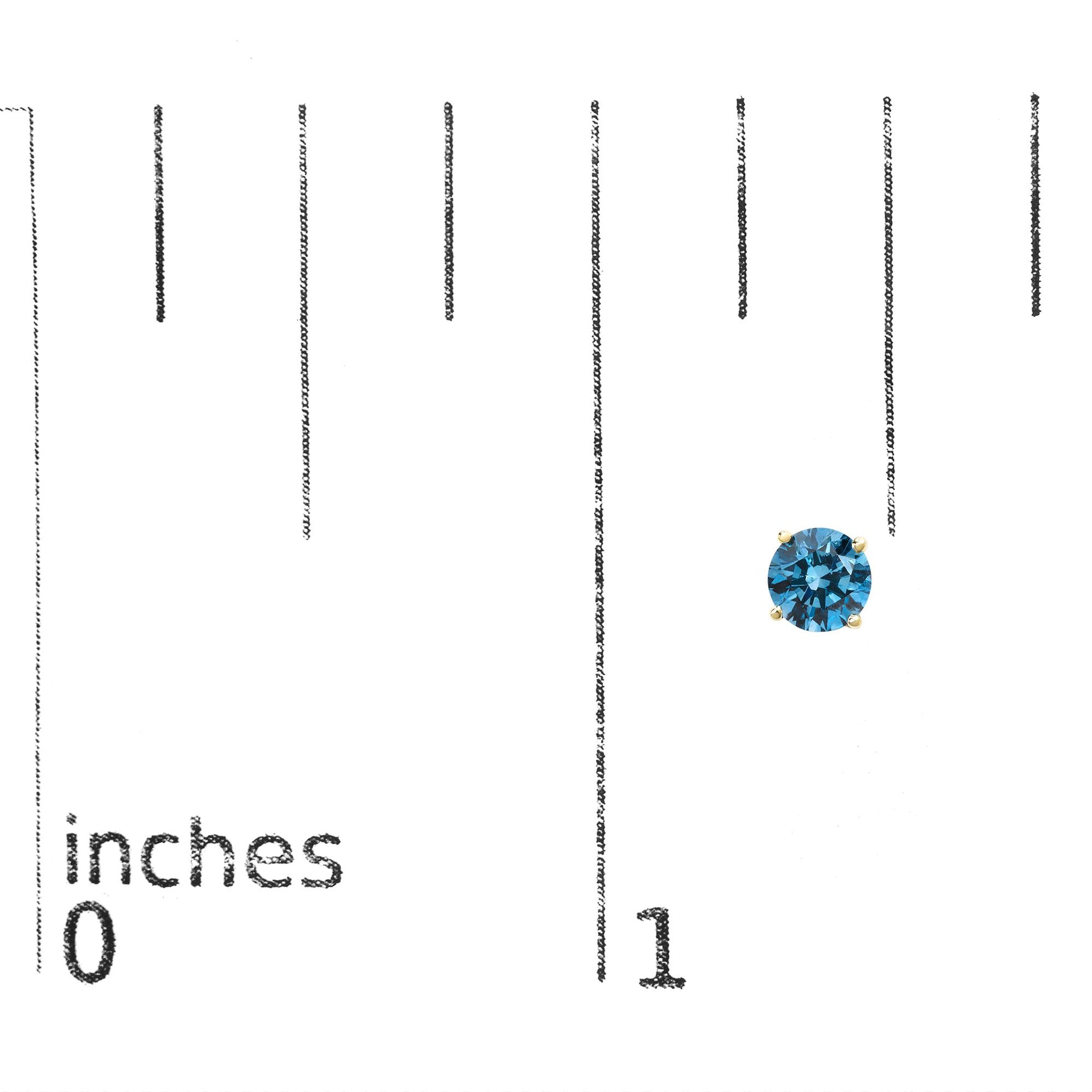 Close-up front view of a yellow metal stud earring with a round blue gemstone in a four-prong setting, placed on a ruler for size reference.