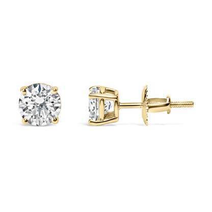 Pair of yellow metal stud earrings with round white gemstones in a 4-prong setting, shown from front and side angles on a white background.