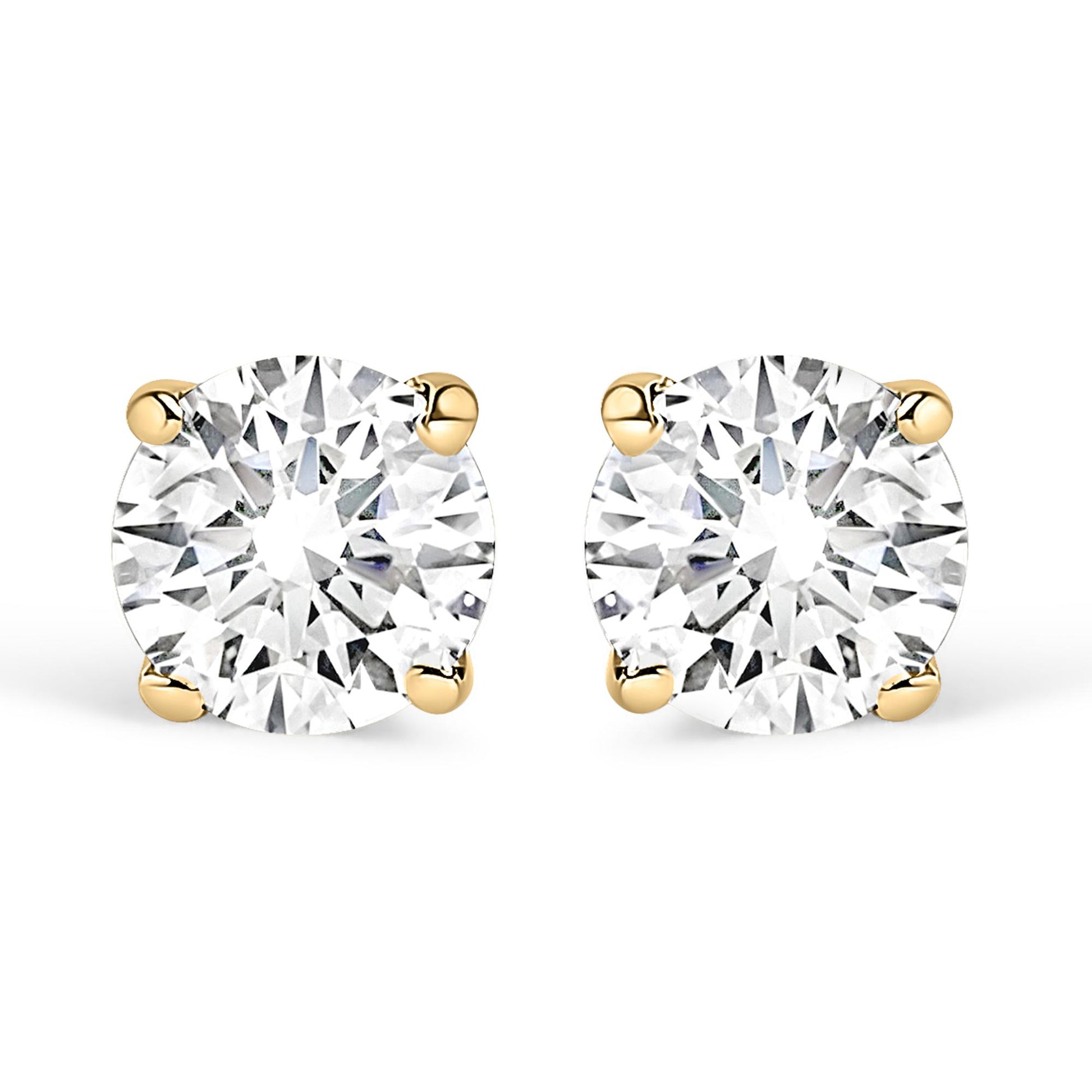 Front view of yellow metal stud earrings with round white gemstones in four-prong settings.