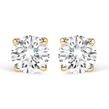 Front view of yellow metal stud earrings with round white gemstones in four-prong settings.