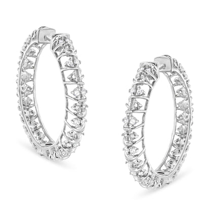 Pair of white metal hoop earrings adorned with prong-set round white gemstones, shown from a front angle.