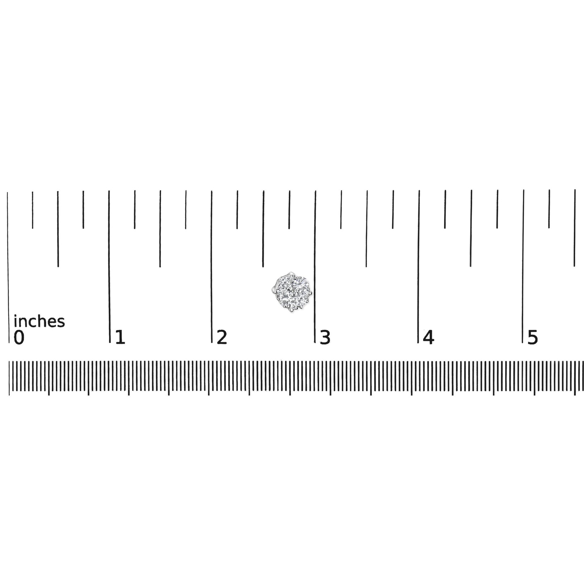 Close-up top view of a white metal round cluster earring with multiple white gemstones in prong settings placed on a ruler for size reference.