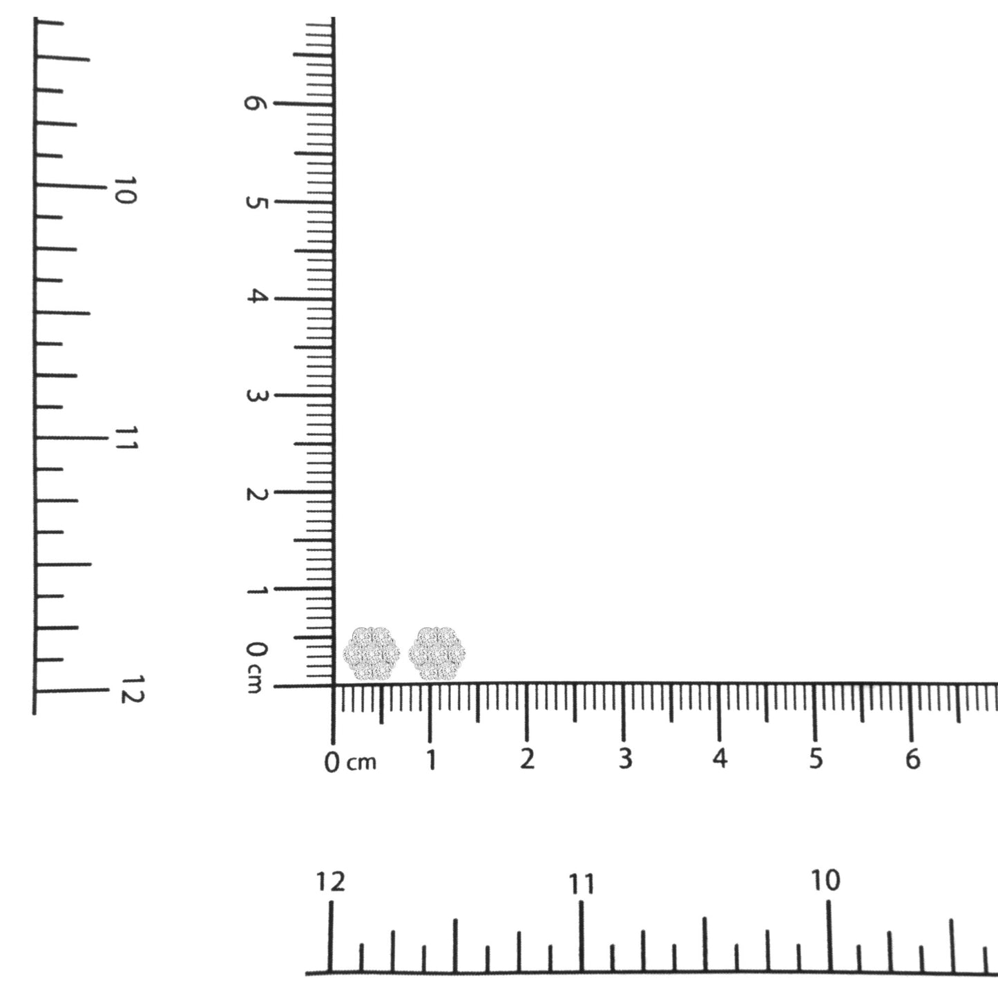 Pair of white metal round cluster earrings with white gemstones in shared prong settings, placed on a ruler for size reference, top-down angle.