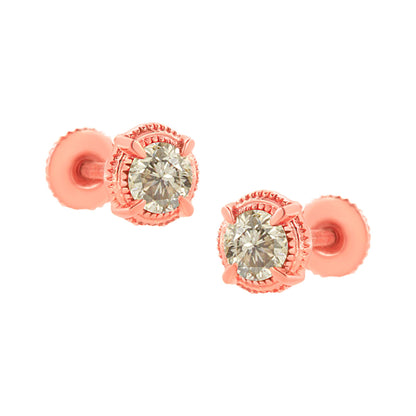 Pair of rose metal stud earrings with round brownish gemstones in prong settings, shown from a front angle.