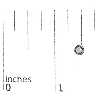 Close-up front angle of a white metal earring with a single round white gemstone in prong setting, placed on a ruler for size reference.