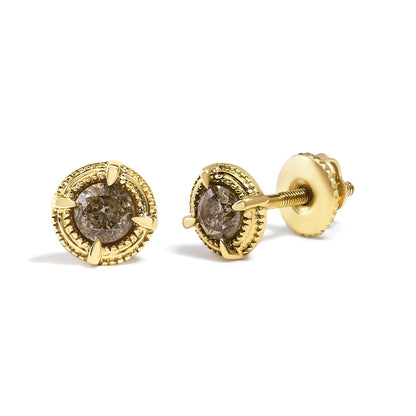 Pair of yellow metal stud earrings with round brownish gemstones in prong settings, shown at a slight angle on a white background.