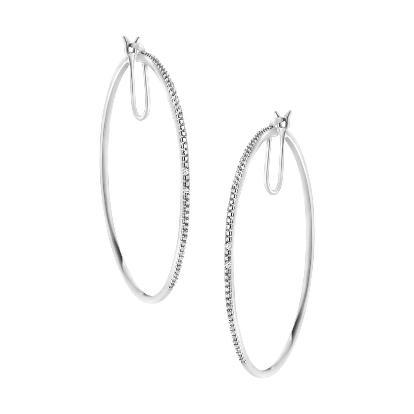 Pair of white metal hoop earrings with round white gemstones in prong settings along one outer edge, shown from a front angle.