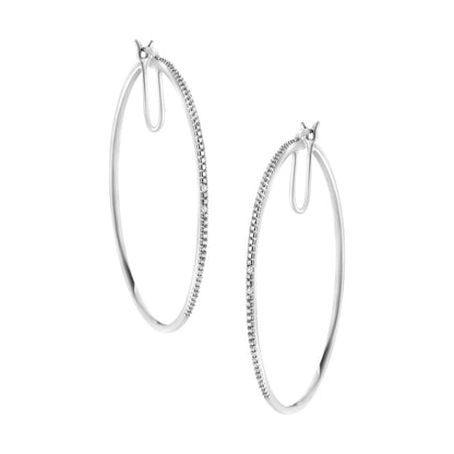 Pair of white metal hoop earrings with round white gemstones in prong settings along one outer edge, shown from a front angle.