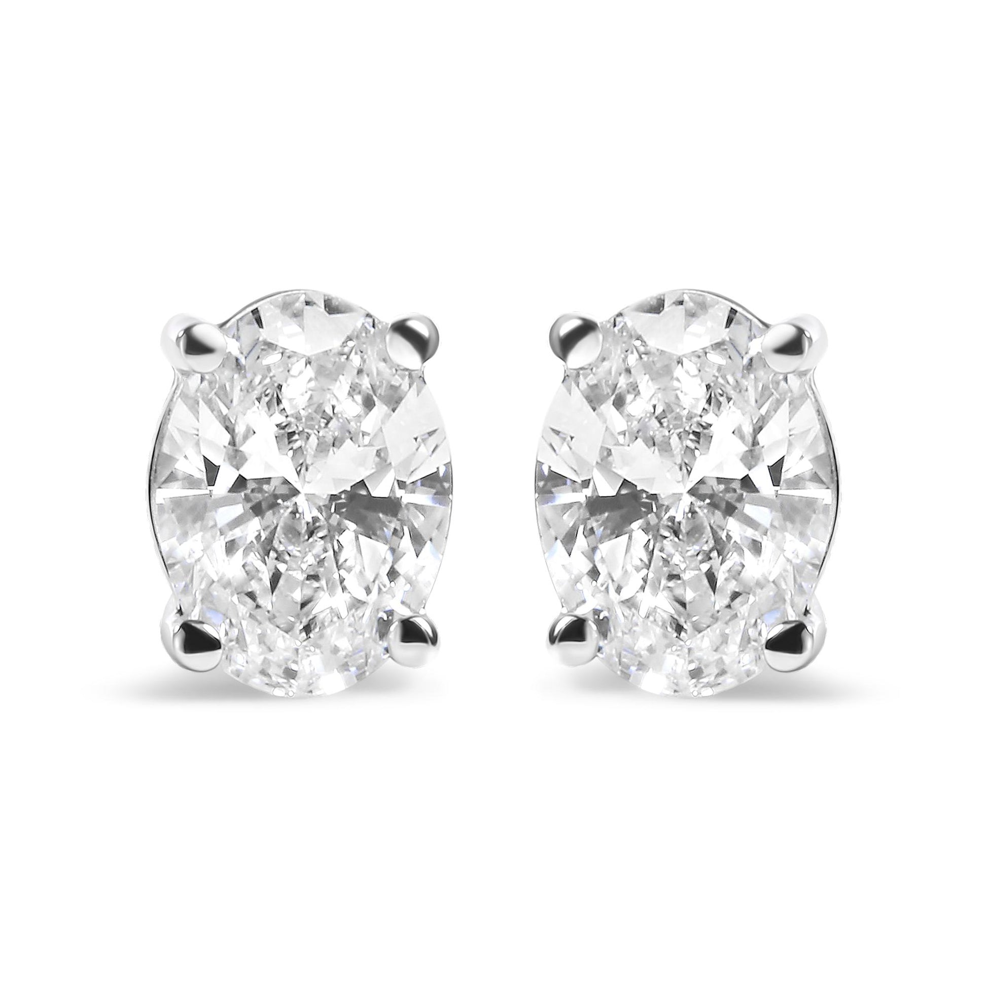 Front view of white metal stud earrings featuring oval-shaped white gemstones in a four-prong setting.