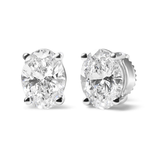 Pair of white metal stud earrings with oval-shaped white gemstones in four-prong settings, shown from a front-right angle.
