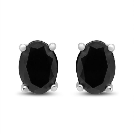 Front-facing view of white metal stud earrings featuring oval-shaped black gemstones in four-prong settings.