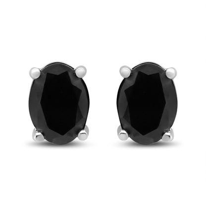 Front-facing view of white metal stud earrings featuring oval-shaped black gemstones in four-prong settings.