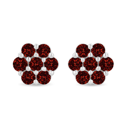 Pair of white metal earrings with round red gemstones in prong settings, front-facing shot.