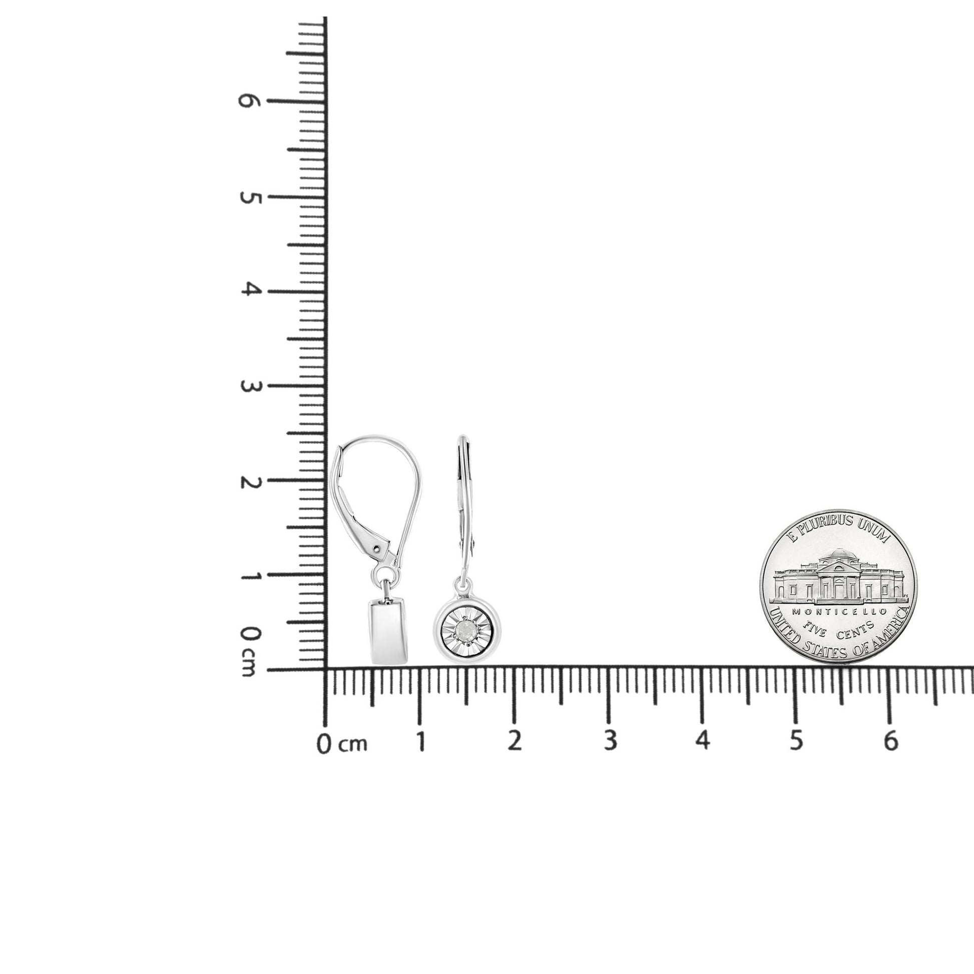 White metal round-shaped earrings with miracle setting white gemstones, displayed side by side on a ruler for size reference, shown from front and side angles.