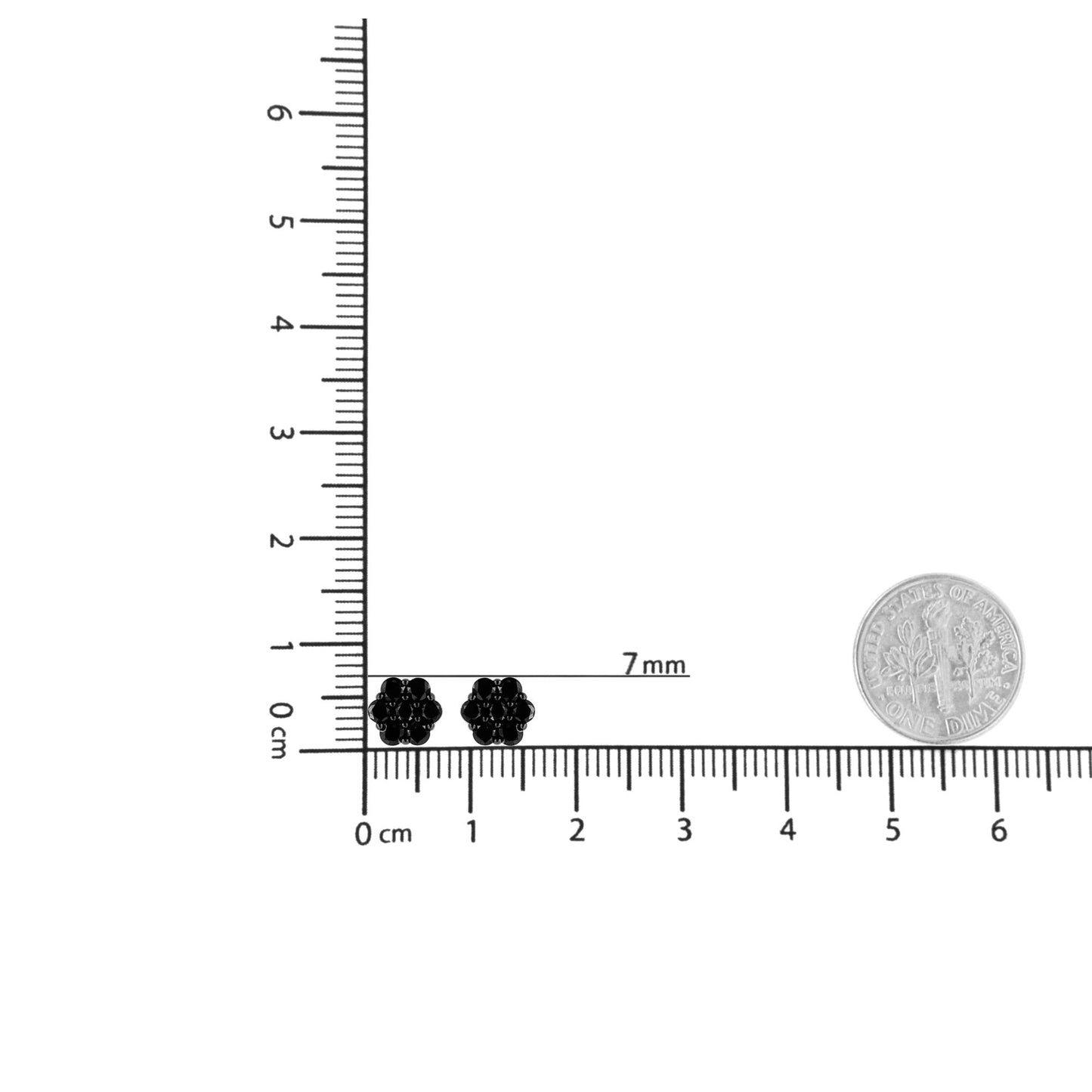 Close-up of white metal stud earrings with round black gemstones in prong settings, placed on a ruler for size reference, shot from above.