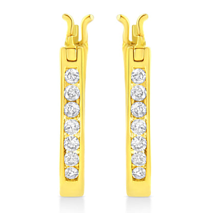 Front view of yellow metal earrings with round white gemstones set in a channel setting along the length.