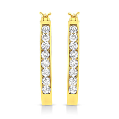 Front-facing view of a pair of yellow metal hoop earrings with a vertical row of round white gemstones set in a channel setting.