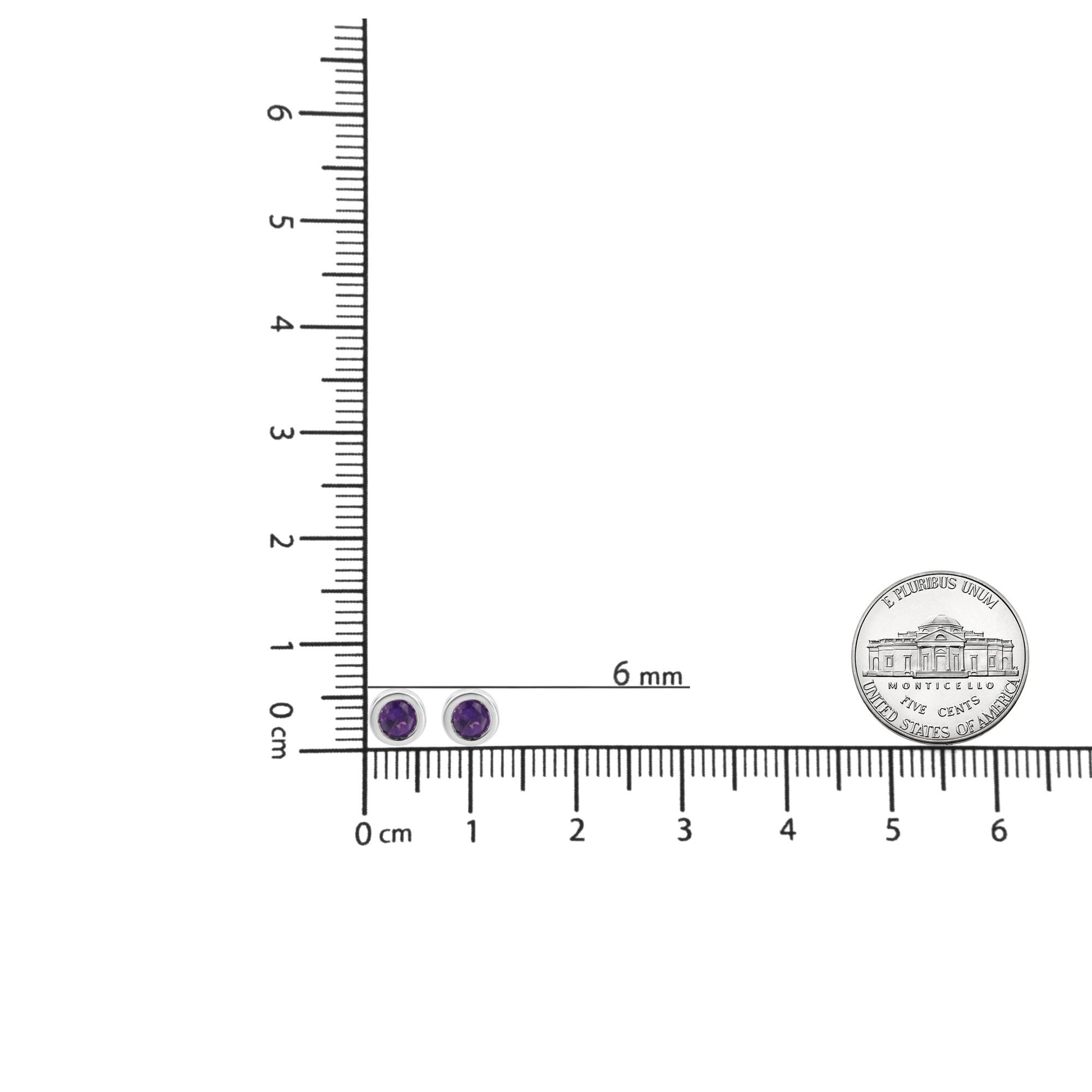 White metal stud earrings with round purple gemstones in bezel settings, shown resting on a ruler and scale for size reference, top-down angle.