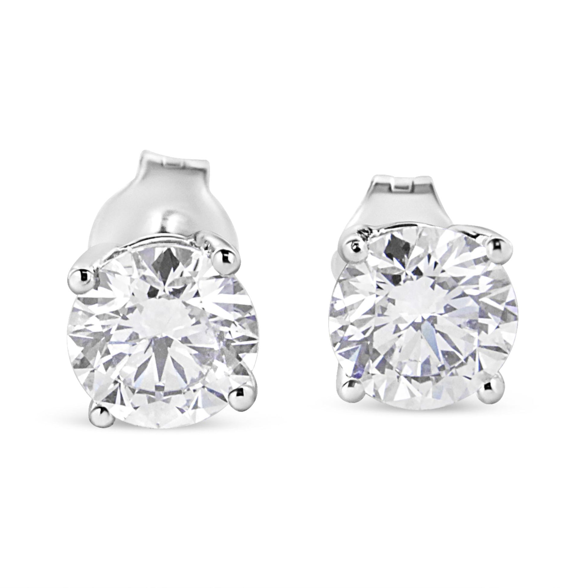 Front view of white metal stud earrings with round white gemstones in four-prong settings.