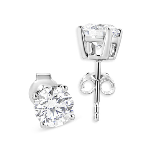 Close-up front and side angle view of a pair of white metal stud earrings with round white gemstones in four-prong settings.
