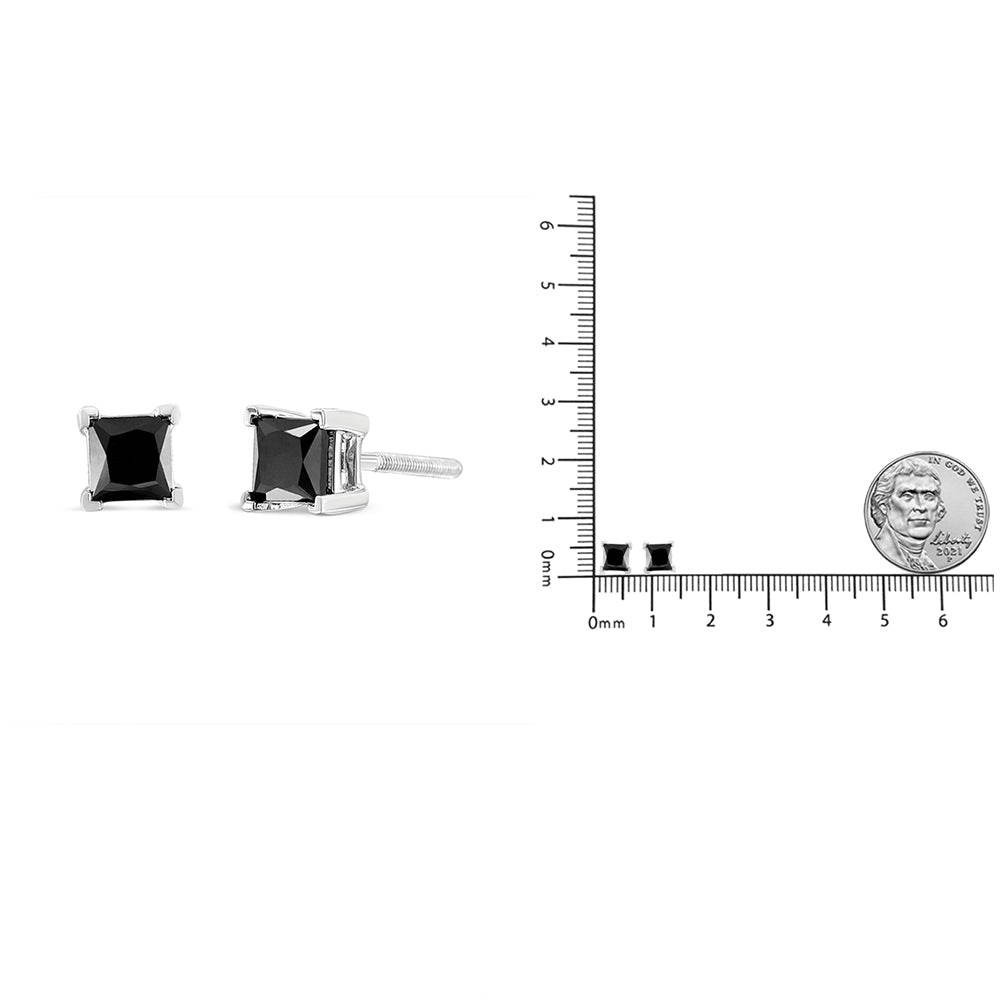Pair of white metal stud earrings with square black gemstones in prong settings, shown from front and side angles; earrings displayed on a ruler and scale for size reference with a coin nearby.