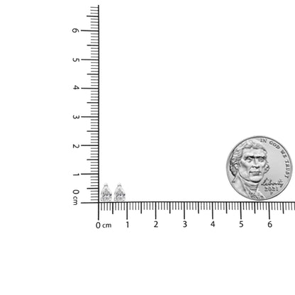 Front angle of white metal pear-shaped earrings with white gemstones in 3-prong settings, placed on a ruler and beside a coin for size reference.