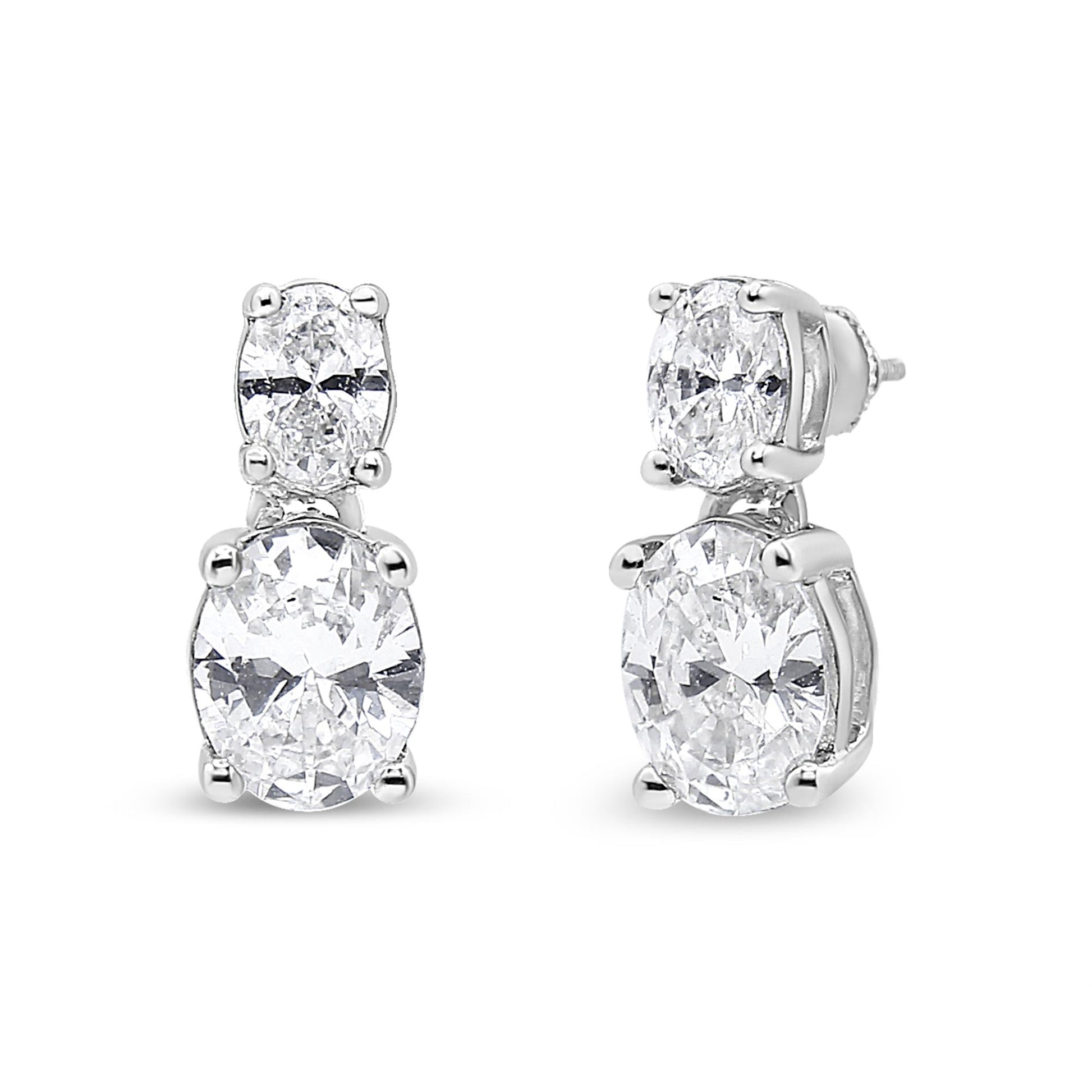Front and side angled view of white metal drop earrings with two oval white gemstones in 4-prong settings on each earring.
