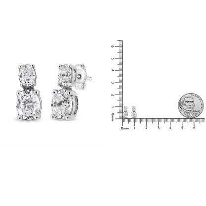 Pair of white metal earrings with two oval-shaped white gemstones in 4-prong settings, shown from a front and side angle, alongside a ruler and coin for size reference.