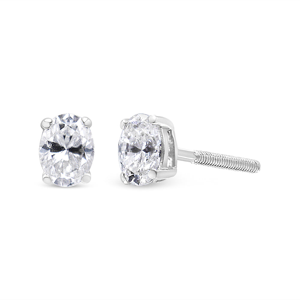 White metal stud earrings with oval white gemstones in four-prong settings, shown from front and side angles on a white background.