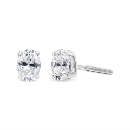 White metal stud earrings with oval white gemstones in four-prong settings, shown from front and side angles on a white background.