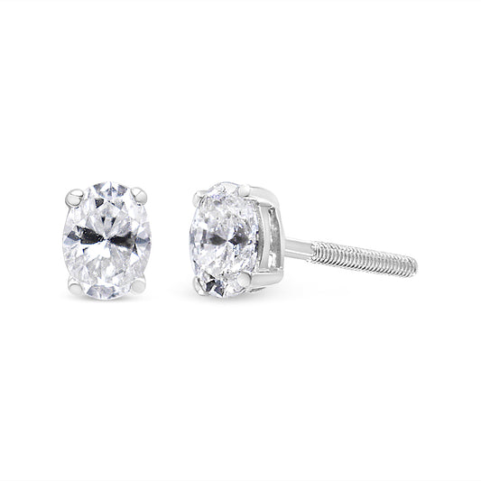 White metal stud earrings with oval white gemstones in four-prong settings, shown from front and side angles on a white background.